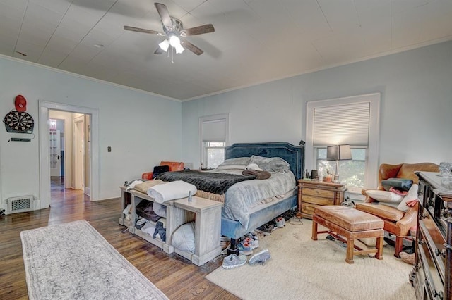 bedroom featuring ceiling fan, crown molding, and dark hardwood / wood-style floors