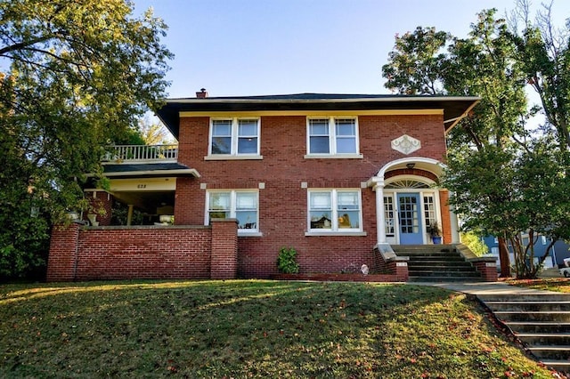 view of property featuring a balcony and a front yard