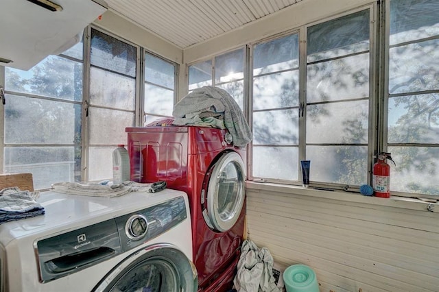 laundry room with independent washer and dryer and wooden walls