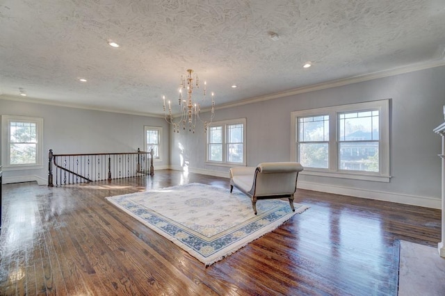 unfurnished room featuring plenty of natural light, dark hardwood / wood-style floors, ornamental molding, and a textured ceiling