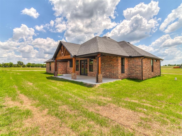 2233 W Sunset Dr, Mustang, OK 73064 - view of home's exterior with a patio, brick siding, a yard, and roof with shingles