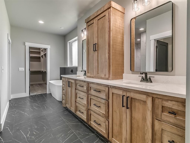 2233 W Sunset Dr, Mustang, OK 73064 - bathroom featuring a freestanding tub, double vanity, baseboards, recessed lighting, and marble look tiles