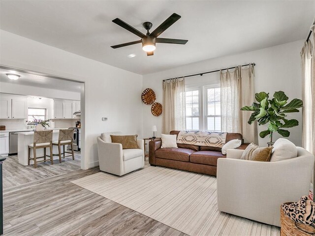 living room featuring ceiling fan and light hardwood / wood-style floors