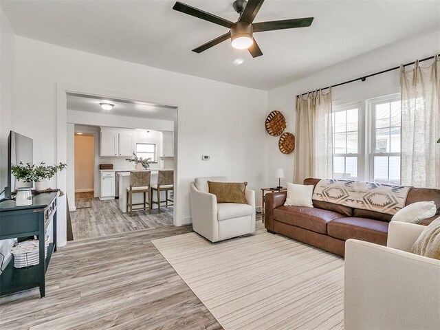 living room featuring light hardwood / wood-style floors and ceiling fan