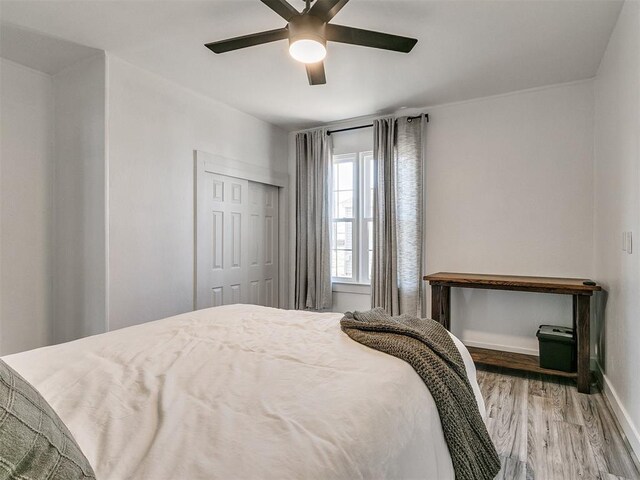 bedroom with hardwood / wood-style floors, a closet, and ceiling fan