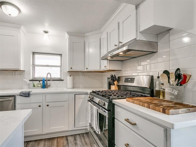 kitchen featuring backsplash, white cabinets, sink, light wood-type flooring, and appliances with stainless steel finishes