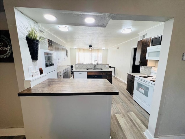 kitchen with decorative backsplash, sink, white appliances, and wood counters