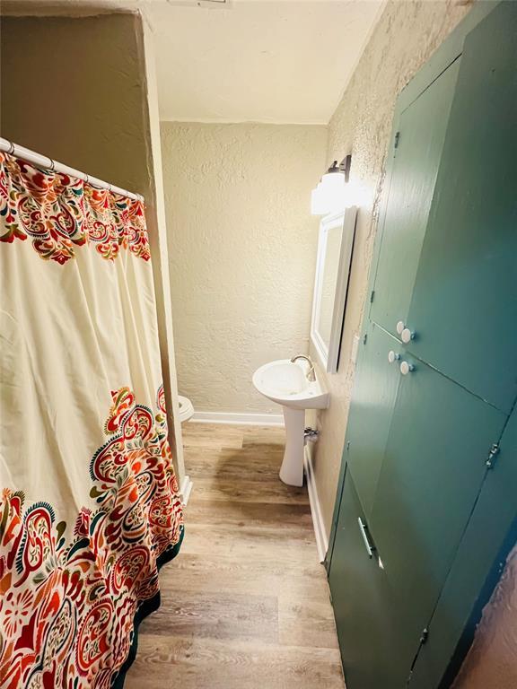 bathroom featuring hardwood / wood-style flooring and toilet