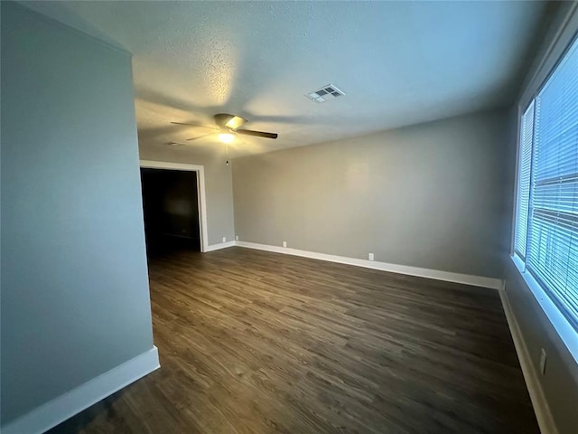 unfurnished room featuring a textured ceiling, dark hardwood / wood-style floors, and ceiling fan