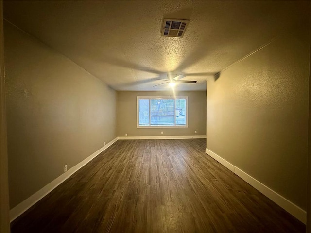 spare room with ceiling fan, dark wood-type flooring, and a textured ceiling