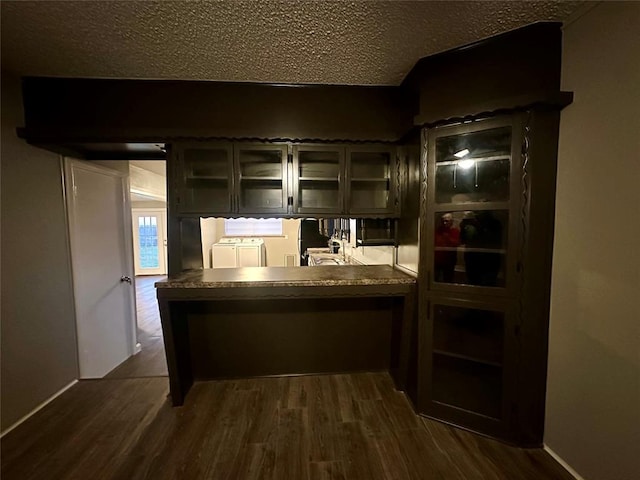 bar with a textured ceiling, dark wood-type flooring, and washer / clothes dryer