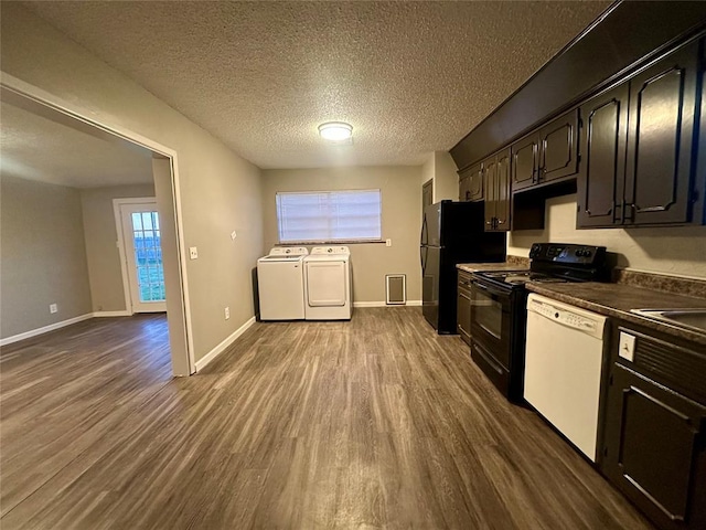 kitchen with dark brown cabinets, a textured ceiling, black appliances, washer and dryer, and hardwood / wood-style floors