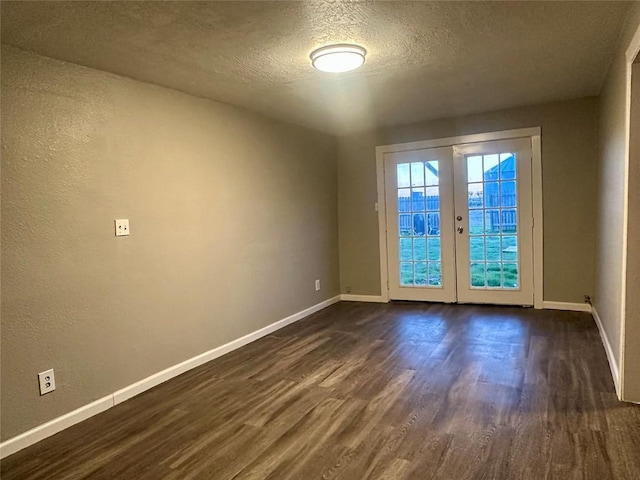 unfurnished room with a textured ceiling, french doors, and dark hardwood / wood-style floors