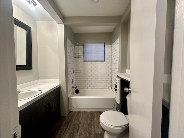 full bathroom with hardwood / wood-style floors, vanity, toilet, and tiled shower / bath