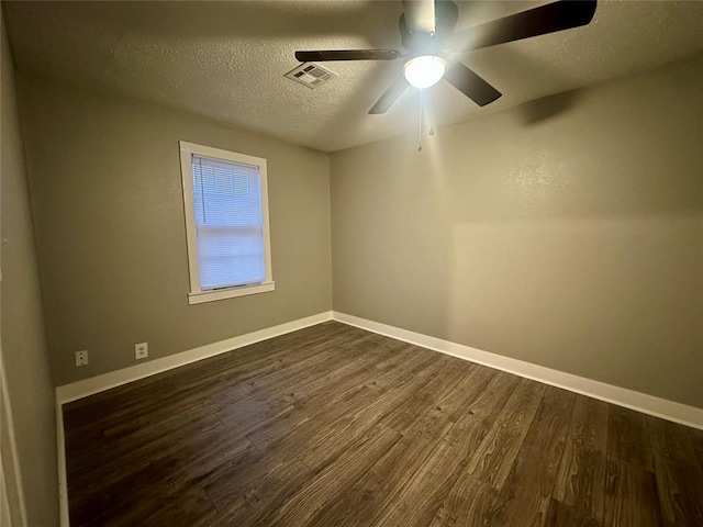 empty room featuring ceiling fan, dark hardwood / wood-style flooring, and a textured ceiling