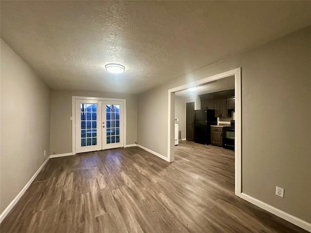 empty room featuring hardwood / wood-style floors, a textured ceiling, and french doors