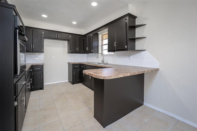 kitchen featuring kitchen peninsula, light tile patterned floors, tasteful backsplash, and sink