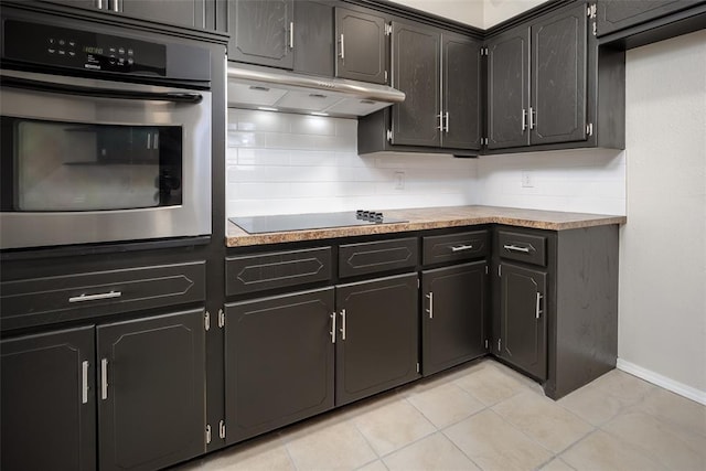 kitchen featuring light tile patterned floors, backsplash, black electric cooktop, and oven