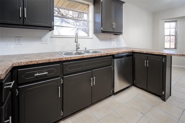 kitchen featuring kitchen peninsula, backsplash, sink, light tile patterned floors, and dishwasher