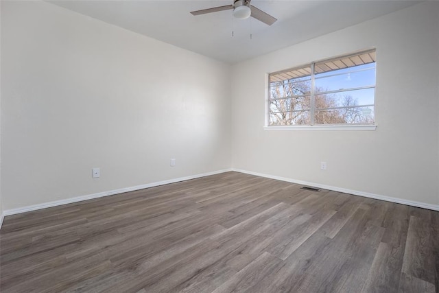 spare room with ceiling fan and dark hardwood / wood-style flooring