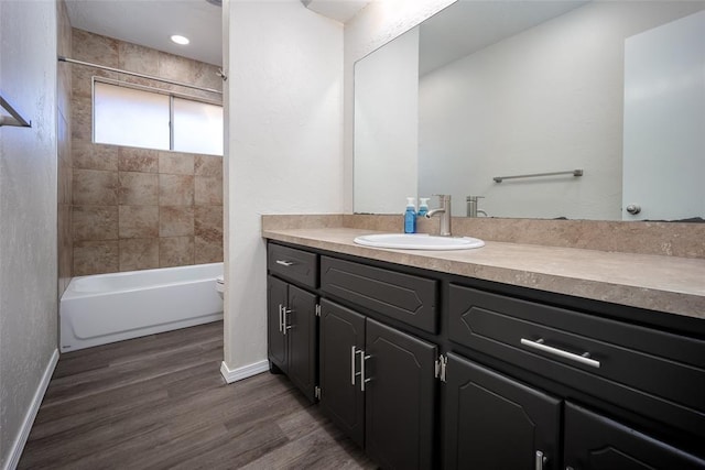 bathroom featuring hardwood / wood-style floors, vanity, and tiled shower / bath combo