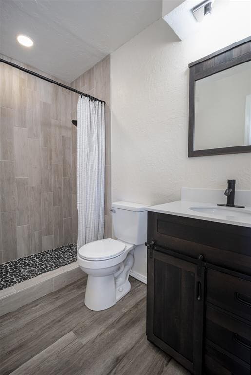 bathroom featuring vanity, toilet, wood-type flooring, and walk in shower