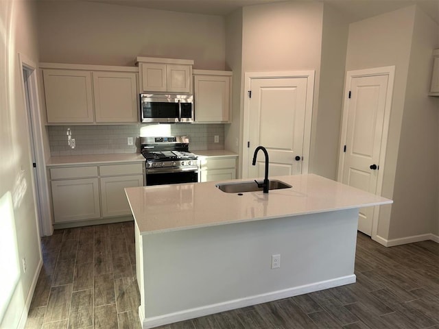 kitchen featuring tasteful backsplash, a kitchen island with sink, sink, and appliances with stainless steel finishes