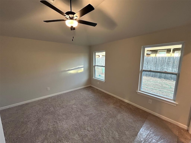 carpeted spare room featuring ceiling fan