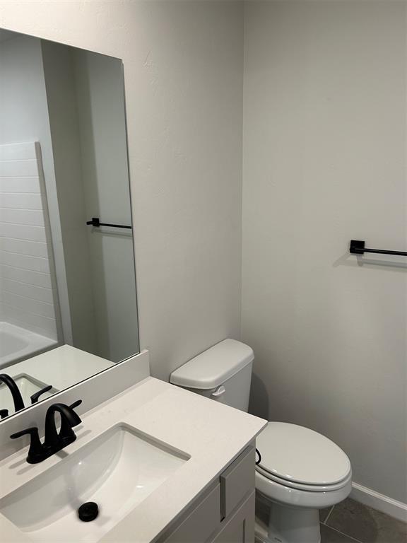 bathroom featuring tile patterned flooring, vanity, and toilet