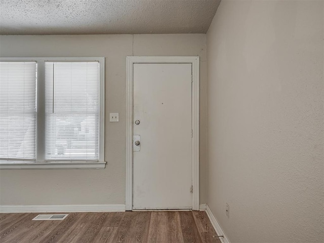 foyer featuring hardwood / wood-style flooring and a textured ceiling