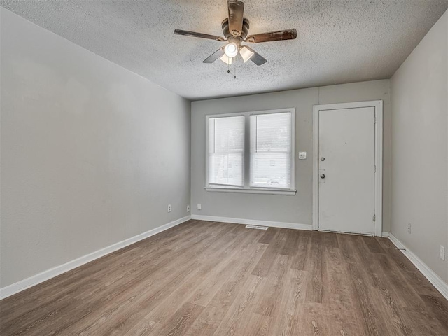 spare room featuring wood-type flooring, a textured ceiling, and ceiling fan