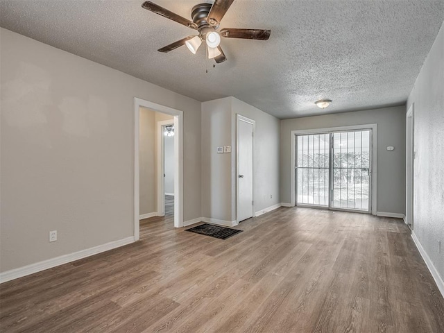 empty room featuring ceiling fan, a textured ceiling, and light hardwood / wood-style flooring