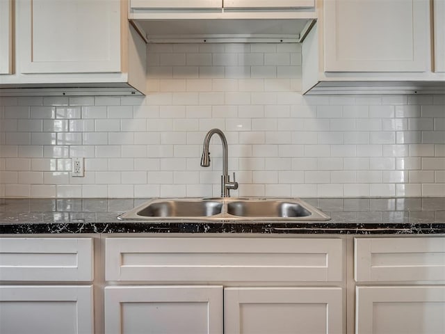 kitchen featuring tasteful backsplash, sink, and white cabinets