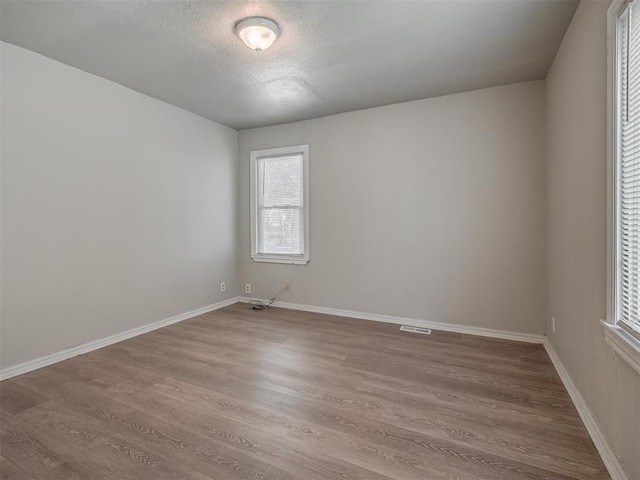 spare room with a textured ceiling and hardwood / wood-style flooring