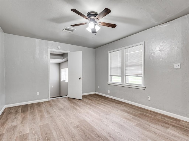 empty room with ceiling fan and light wood-type flooring