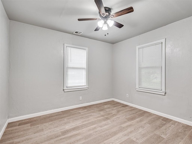 empty room with ceiling fan and light hardwood / wood-style floors