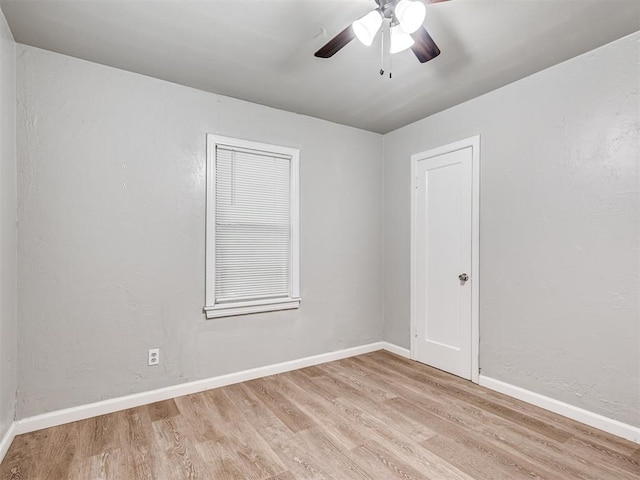 empty room with ceiling fan and light hardwood / wood-style floors