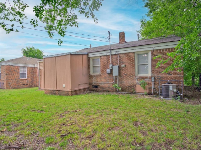 rear view of property featuring a yard and cooling unit