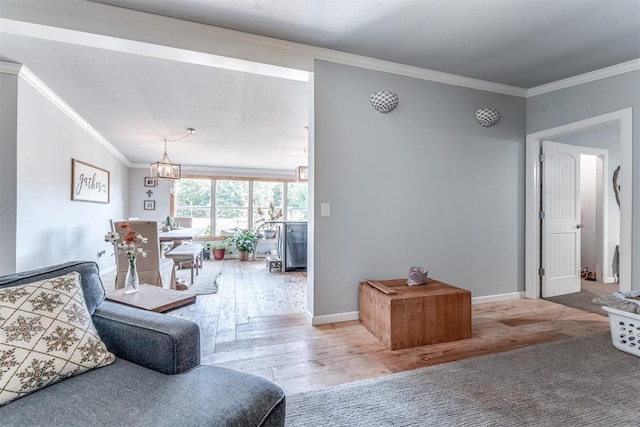 living room featuring hardwood / wood-style floors, an inviting chandelier, and crown molding