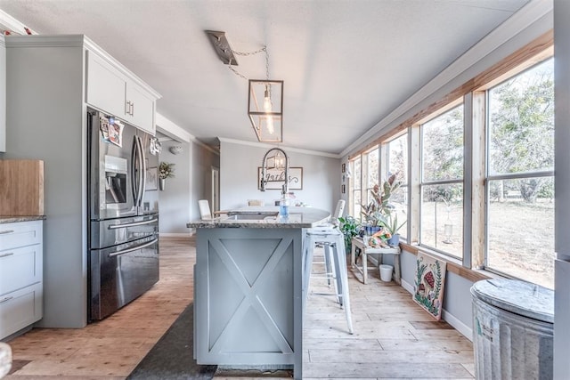 kitchen featuring white cabinets, plenty of natural light, and stainless steel fridge