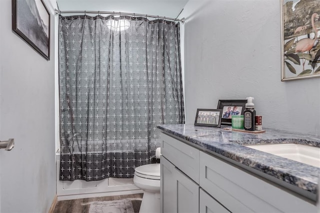 full bathroom featuring shower / bathtub combination with curtain, hardwood / wood-style floors, vanity, and toilet