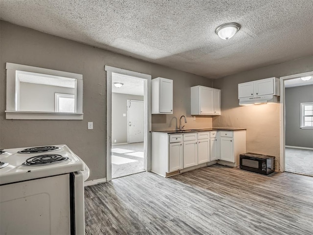 kitchen featuring a textured ceiling, sink, white cabinets, light hardwood / wood-style floors, and white range with electric cooktop