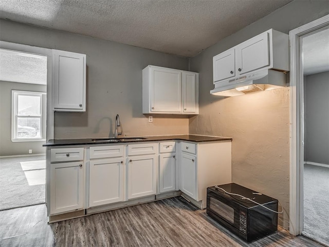 kitchen with white cabinetry, sink, and a textured ceiling