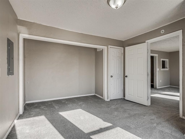 unfurnished bedroom with dark colored carpet, a textured ceiling, electric panel, and a closet