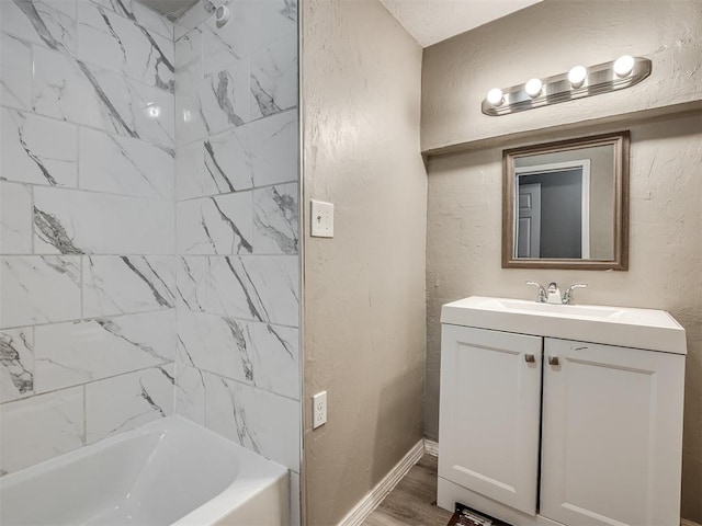 bathroom with vanity, wood-type flooring, and tiled shower / bath combo