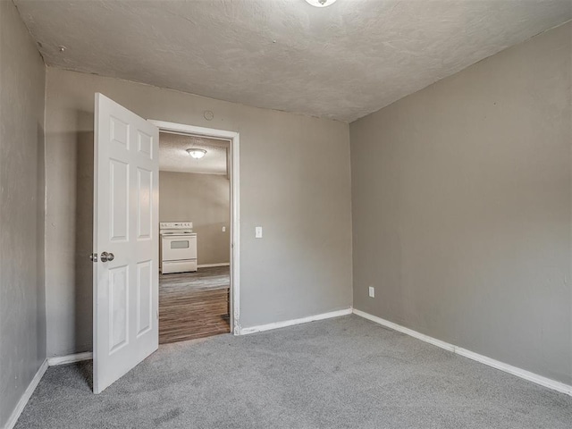 spare room featuring carpet floors and a textured ceiling