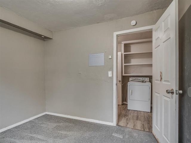 clothes washing area with carpet flooring, a textured ceiling, and washer / dryer