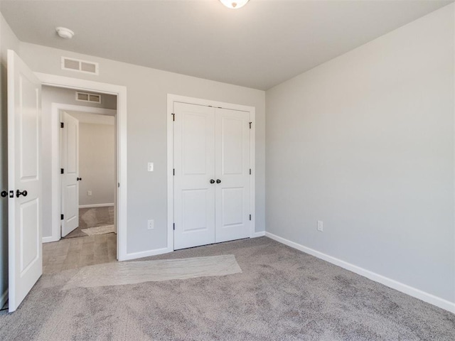 unfurnished bedroom with carpet floors, baseboards, and visible vents