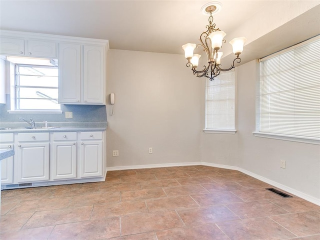 unfurnished dining area with sink and a notable chandelier