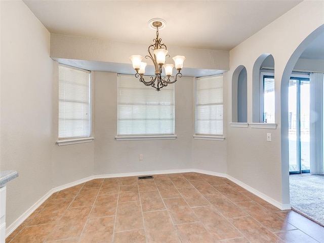 unfurnished dining area featuring light tile patterned floors and an inviting chandelier